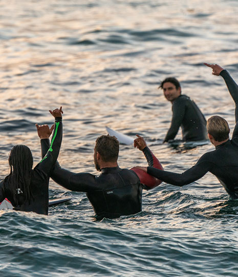 Men sitting on surfboards waiting to catch waves